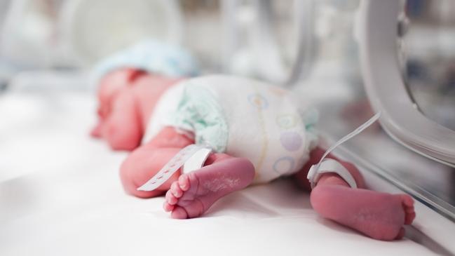 Newborn baby boy covered in vertix inside incubator. iStock Image - Generic