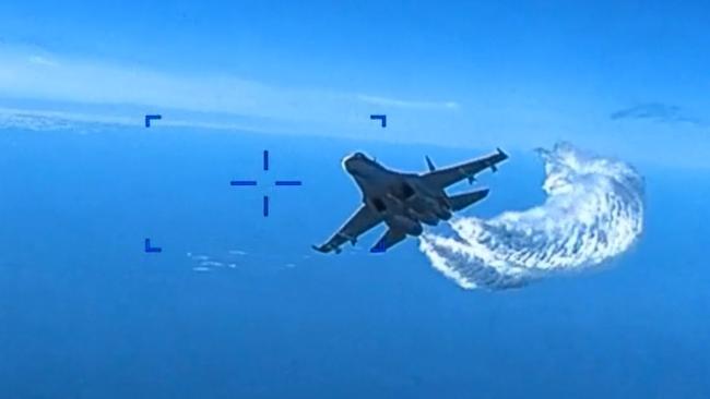 A Russian Su-27 fighter jet flies near an American MQ-9 Reaper drone, spraying what the US government says is jet fuel over the Black Sea near Crimea on Tuesday. Picture: US Defence Department European Command / Getty Images