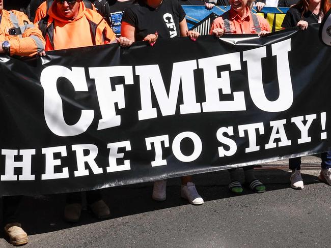 Protesters hold banners and chant slogans as they march in support of the Construction, Forestry and Maritime Employees Union (CFMEU) in central Sydney on September 18, 2024. Thousands of trade workers joined marches in Melbourne and Sydney to protest against the federal government's decision to force the CFMEU's construction arm into administration. (Photo by DAVID GRAY / AFP)