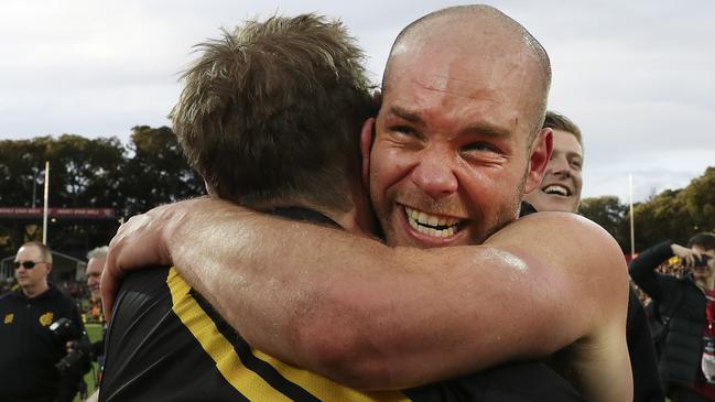 Glenelg player Aaron Joseph hugs coach Mark Stone after the drought-breaking win. Picture SARAH REED