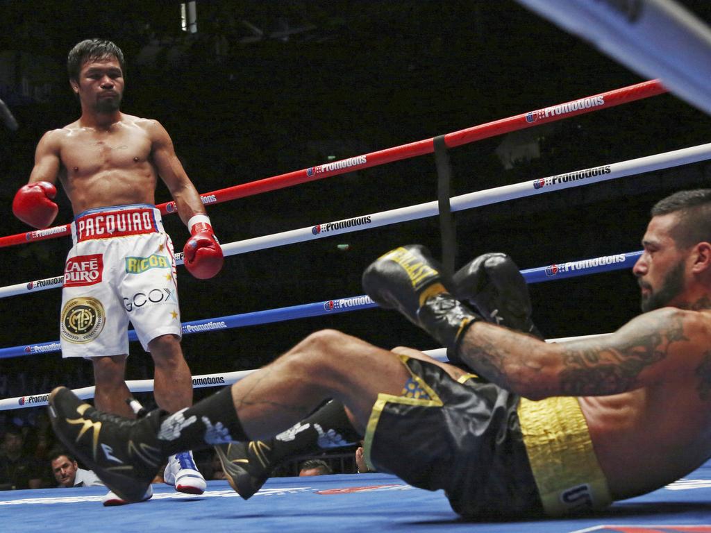 Lucas Matthysse, left, of Argentina falls after receiving a punch by Manny Pacquiao of the Philippines during their WBA World welterweight title bout in Kuala Lumpur, Malaysia, Sunday, July 15, 2018. Filipino boxing legend Pacquiao clinched his 60th victory Sunday with a seventh-round knockout of Matthysse, his first stoppage in nine years, that will help revive his career. (AP Photo/Yam G-Jun)