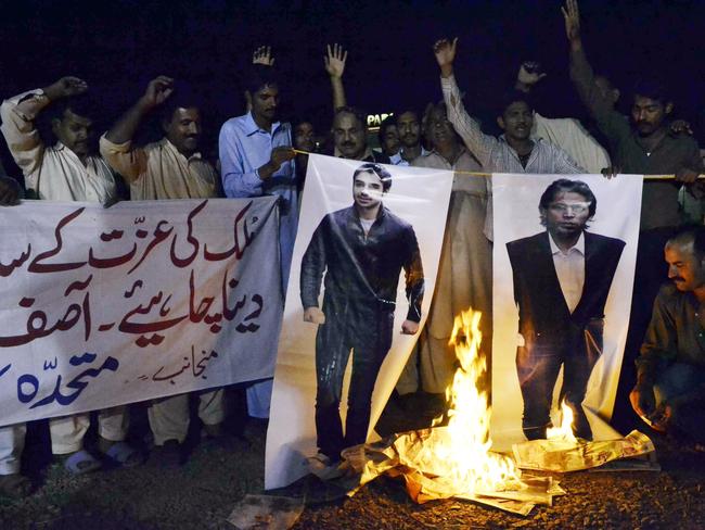 Pakistani protesters burn the photographs of former Pakistani cricketers Salman Butt and Mohmmad Asif.