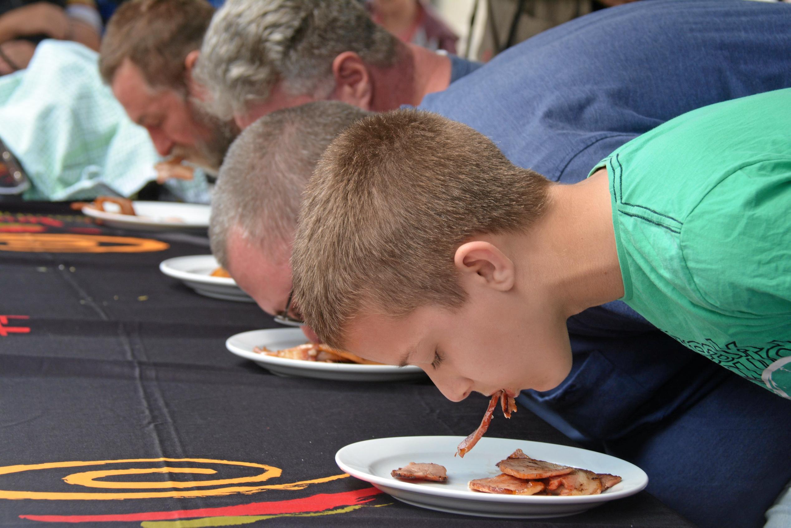 Competitors fight for the top spot at the bacon eating competition during Kingaroy's BaconFest on Saturday August 25. Picture: Jessica McGrath