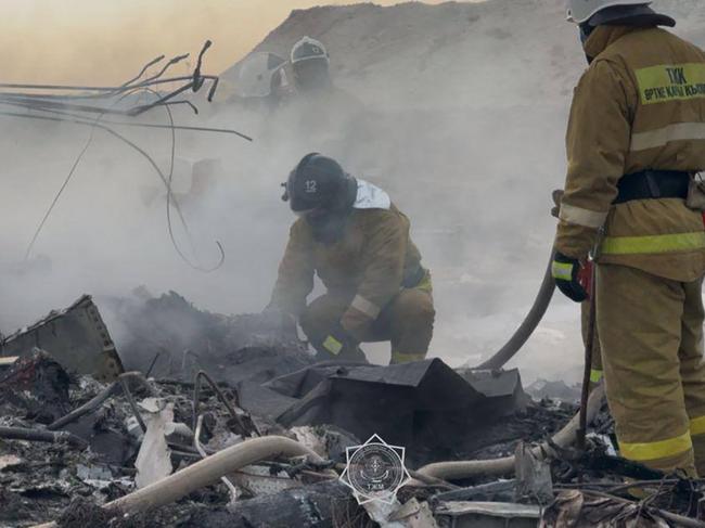 Fire fighters among the smouldering ruins of a passenger jet that exploded into a fireball. Picture: AFP