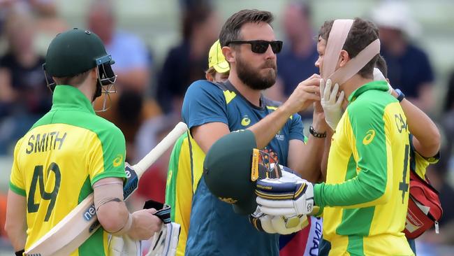 In pain, but fighting on … Australia’s Alex Carey gets his Rick McCosker-like bandage applied. Picture: AFP