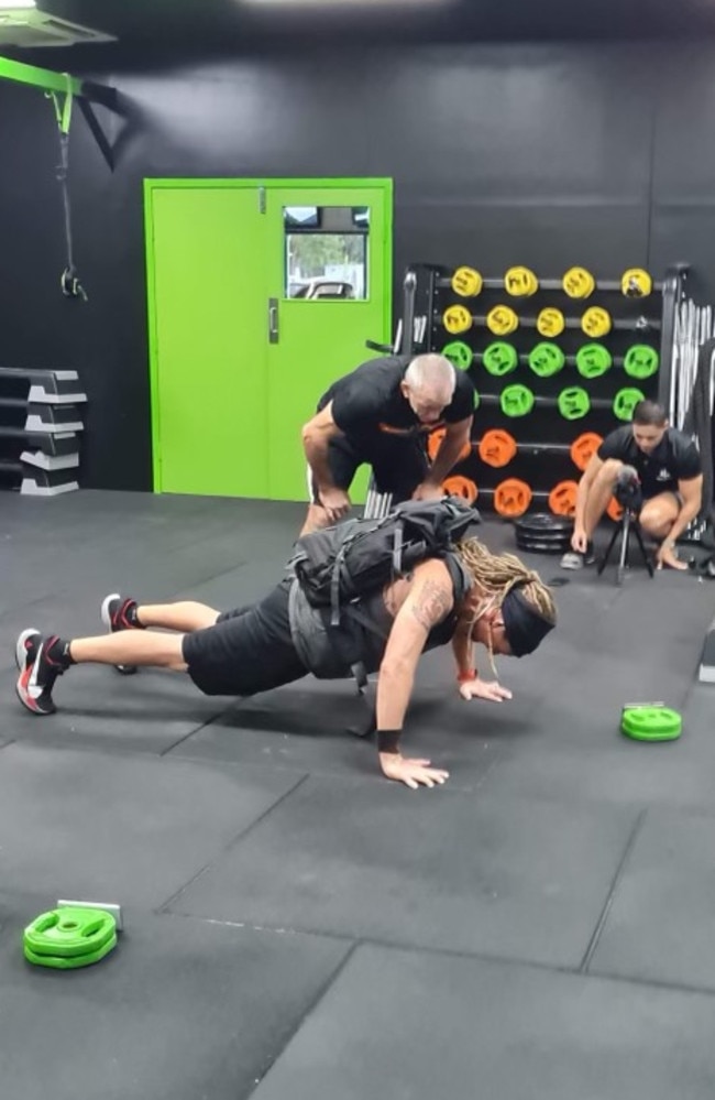 Adam Drake completes 52 push-ups in one minute while carrying a 45kg pack at Darwin's Next Level Gym. Picture: Supplied