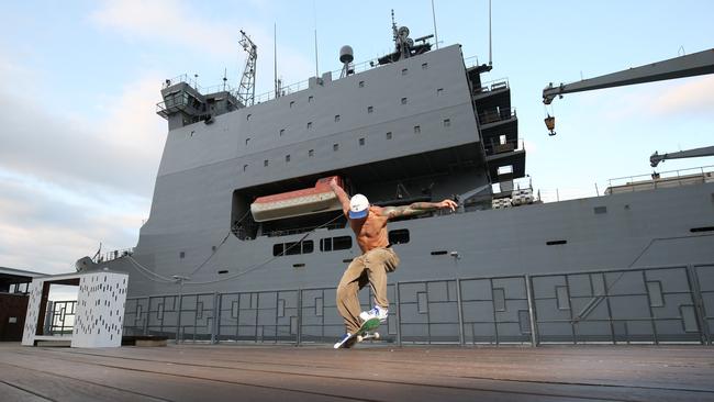 The 16,000 tonne, 176 metre long amphibious landing ship HMAS Choules has docked at the Cairns Wharf impressing people with its sheer size. City resident Nick Kisgyano skates past the large Australian navy vessel. Picture: Brendan Radke