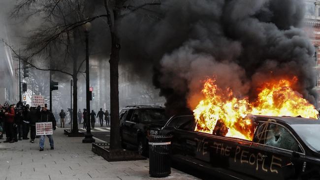 A parked limousine burns during a demonstration. Picture: AP