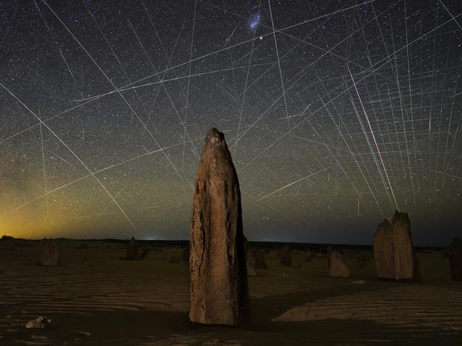 EMBARGO FOR TWAM 02 JULY 2022. FEE MAY APPLY Satellite trails behind Pinnacles. Found in the Nambung National Park in Western Australia for Heart of the Nation. Joshua Rozells / Supplied