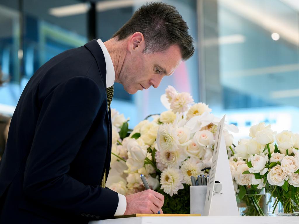 NSW Premier Chris Minns signs a condolence book whilst visiting a memorial to the victims who lost their lives at Westfield Bondi Junction. Picture: Bianca di Marchi - Pool/Getty Images