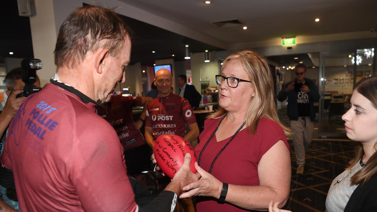 Former prime minister Tony Abbott (left) is handed a "political football" by Wendy Farmer during his visit to the Latrobe Valley in 2018. AAP Image/Joe Castro