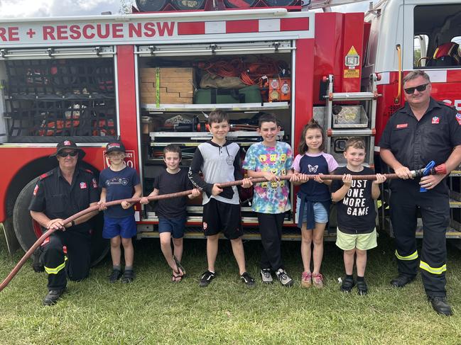 Firefighter Kenny Harrison, Ashton Smith, Riley Nash, Jarrah Robinson, Ryder Davies, McKenzie Robinson, Dexter Robinson and Firefighter Dean Wilson (left to right) pose in front of the Fire + Rescue NSW truck for the 120th Murwillumbah Show. Picture: David Bonaddio