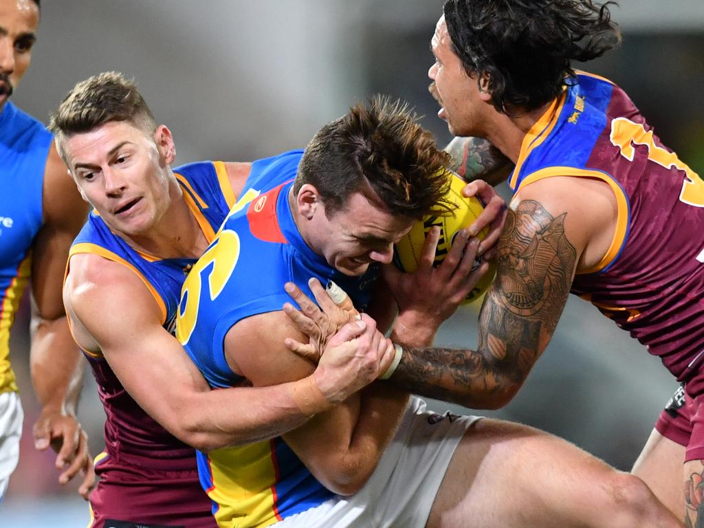 Caleb Graham (centre) of the Suns is tackled by Dayne Zorko and Allen Christensen of the Lions during the Round 21 AFL match between the Brisbane Lions and the Gold Coast Suns at the Gabba in Brisbane, Saturday, August 10, 2019.  (AAP Image/Darren England) NO ARCHIVING, EDITORIAL USE ONLY