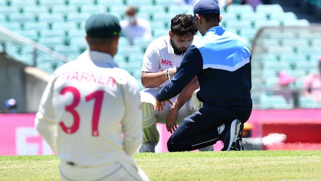 Rishabh Pant is treated after being hit by a ball bowled by Pat Cummins at the SCG.