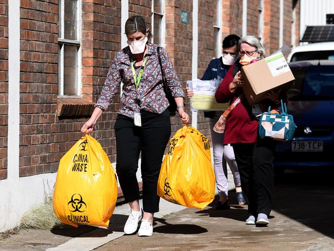 Metro North Health workers leave the hostel. Picture: Dan Peled