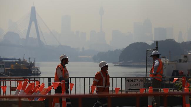 Construction workers carry on as smoke haze drifts over the CBD in Sydney. Picture: AAP