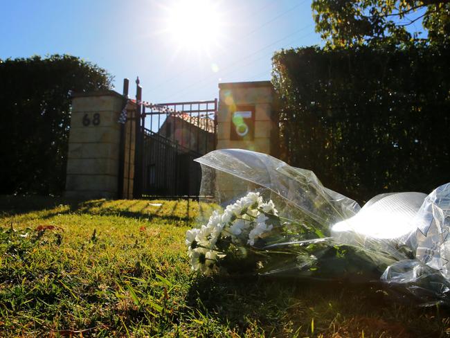 Flowers are being placed by locals outside the Davidson house where the family was found dead. Picture: John Grainger