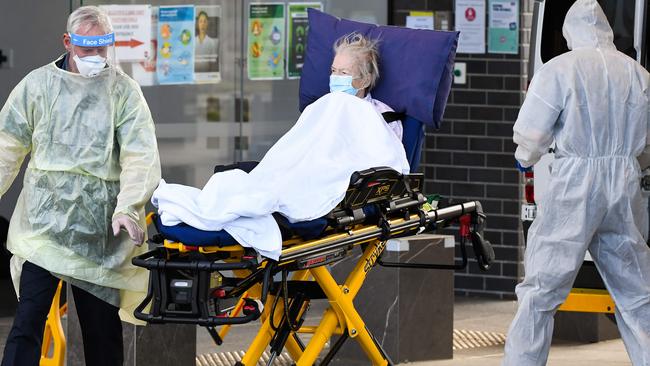 Medical workers evacuate a resident from the Epping Gardens aged care facility. Picture: AFP