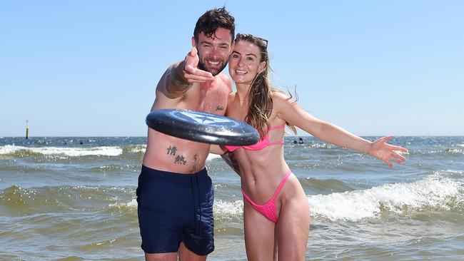 Adam Grisdale and Rebecca Maher soak up the sun at St Kilda Beach. Picture: Josie Hayden