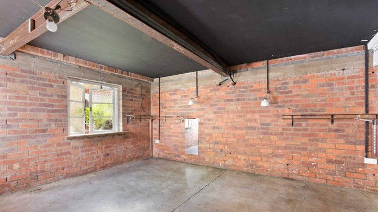 The studio living space, with black painted ceilings and concrete flooring.