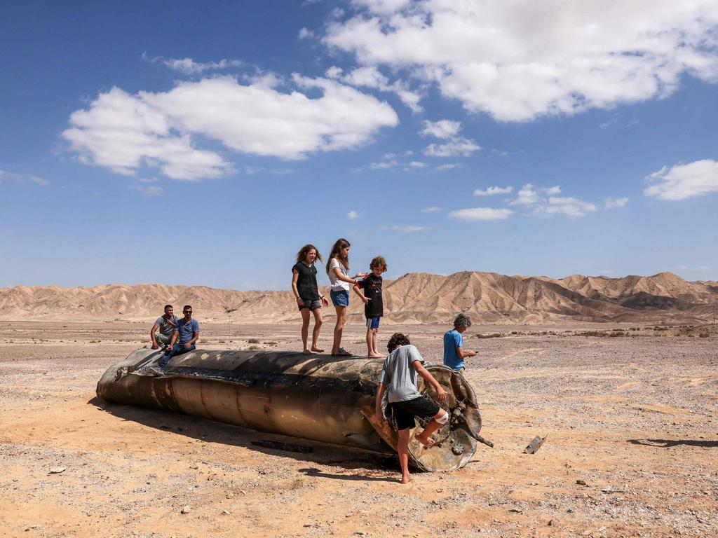 People stand on top of the remains of an Iranian missile in the Negev desert, near Arad, in the aftermath of an Iranian missile attack on Israel, on October 2, 2024. Picture: AFP