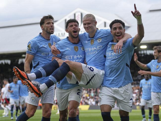 Manchester City players celebrate after Manchester City's Erling Haaland, centre, scored his side's second goal during the English Premier League soccer match between Fulham and Manchester City at Craven Cottage, London, Sunday, May 25, 2025. (AP Photo/Dave Shopland)