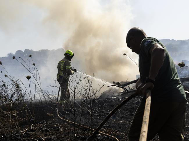 A firefighter and a Kibbutz member extinguish a near the Israel border with Lebanon after a drone attack on June 4, 2024. Picture: Getty Images
