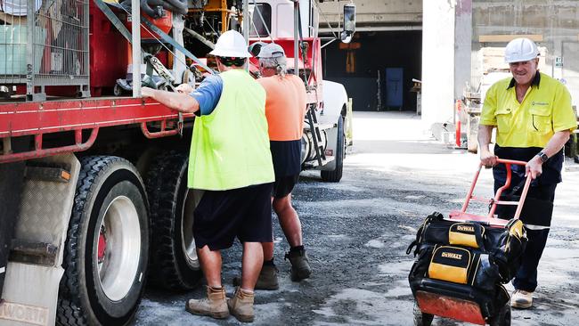 Builders collecting tools and equipment, being watched by security, and leaving the Midwater building site at Main Beach. Picture Glenn Hampson