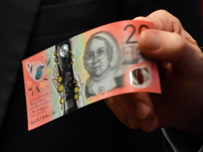 Governor of the Reserve Bank of Australia (RBA), Dr Philip Lowe, holds a new Australian $20 note, soon to be released, as he addresses the House of Representatives Standing Committee on Economics, at NSW State Parliament in Sydney in Sydney, Friday, February, 22, 2019. (AAP Image/Dean Lewins) NO ARCHIVING