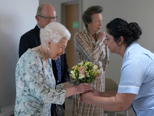 Britain's Queen Elizabeth II receives flowers from a staff member during the visit. Picture: AFP