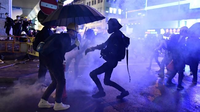 Couples enjoying pizza in a roadside restaurant in Hong Kong had a frontrow seat as a teargas canister exploded outside. Picture: AFP