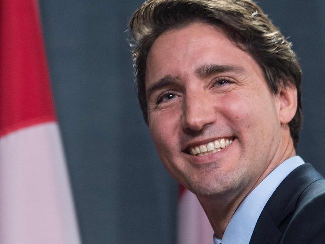 Canadian Liberal Party leader Justin Trudeau smiles at the end of a press conference in Ottawa on October 20, 2015 after winning the general elections. Liberal leader Justin Trudeau reached out to Canada's traditional allies after winning a landslide election mandate to change tack on global warming and return to the multilateralism sometimes shunned by his predecessor. AFP PHOTO/NICHOLAS KAMM