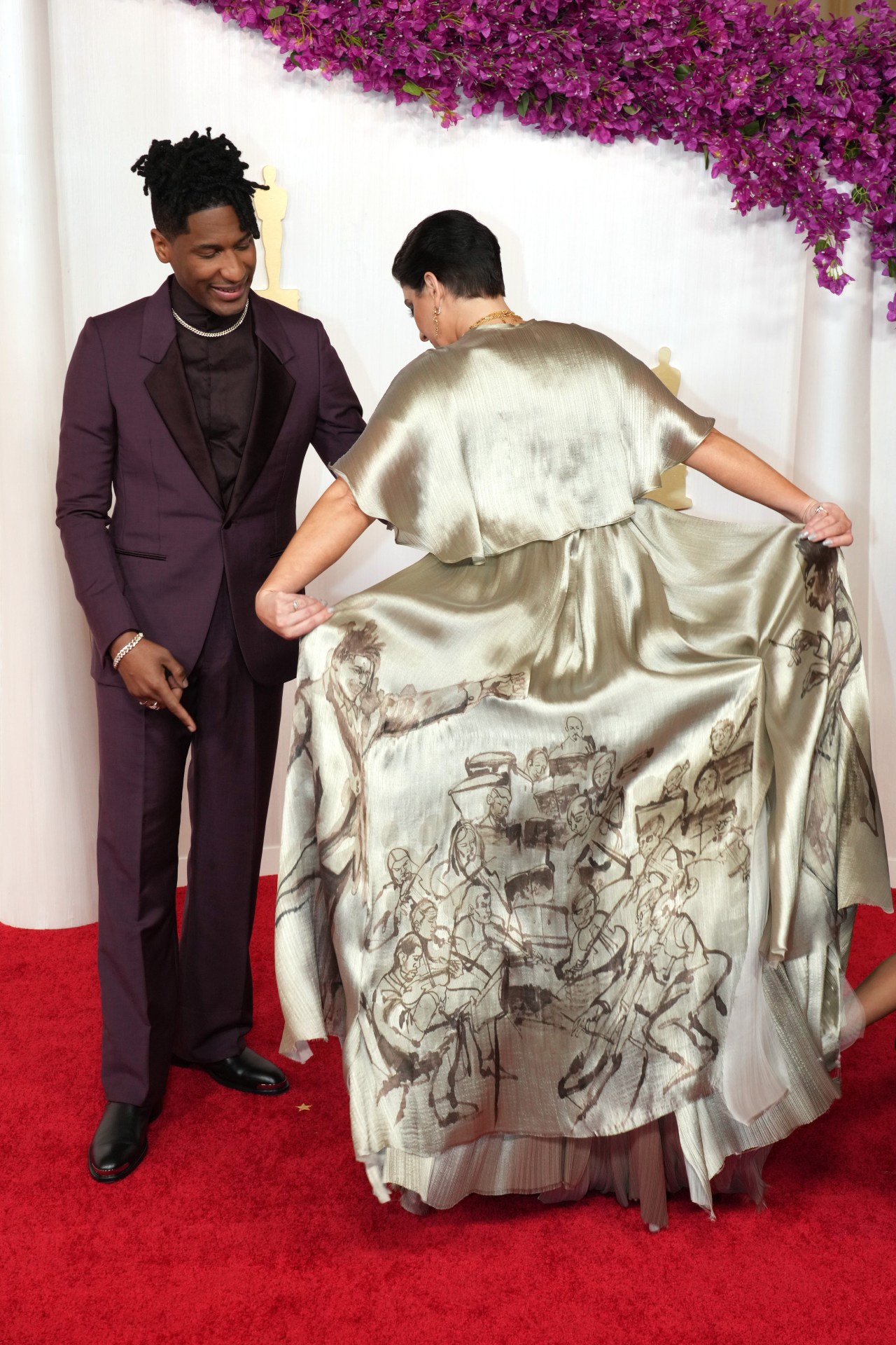 <p>Its modern edge came in the form of a printed sumi-e illustration by artist Chaz Guest of an orchestra and its conductor, drawn to depict Batiste himself in honour of <em>American Symphony</em>,&nbsp;spread out across the dress&rsquo; train. &ldquo;This dress was designed by the one-and-only Angelina Jolie,&rdquo; Jaouad said in a <a href="https://www.tiktok.com/@etalkctv/video/7344935820505255173?_r=1&amp;_t=8kZswfy7eNK" target="_blank" rel="noopener">red-carpet interview</a>. &ldquo;Her first time designing a dress for the red carpet, and she invited the amazing artist Chaz Guest to paint a symphony on the back of it.&rdquo;</p><p>&ldquo;I have such deep admiration for Suleika and the way she lives her life&mdash;how she meets difficulty with strength and grace,&rdquo; Jolie told <a href="https://www.vogue.com/article/angelina-jolie-designs-suleika-jaouad-oscars-dress" target="_blank" rel="noopener"><em>Vogue</em></a>. &ldquo;[She&rsquo;s a] brilliant creative force who inspires everyone who knows her. I would have dressed her for anything she needed; It should never be about the dress, but how anything worn feels like an extension of the person.&rdquo;</p>