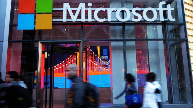 People walk past a Microsoft office in New York.