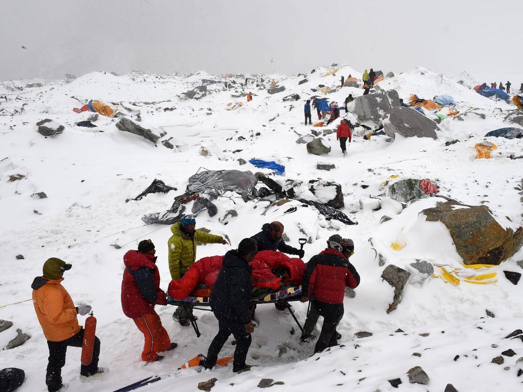 AFP photographer Roberto Schmidt on April 25, 2015 shows rescuers using a makeshift stretcher to carry an injured person after an avalanche triggered by an earthquake flattened parts of Everest Base Camp. AFP’s veteran lensman Roberto Schmidt on February 18, 2016 won second prize at the prestigious World Press Photo Award in the Spot News stories category, for his dramatic shots of the deadly avalanche on Mount Everest triggered by last April’s Nepal earthquake. / AFP / ROBERTO SCHMIDT