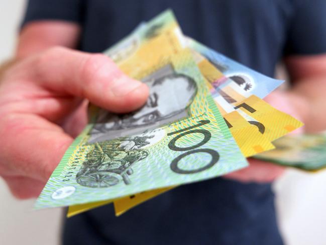 A man handing out Australian dollar bills. A picture that describes buying, paying, handing out money, or showing money.