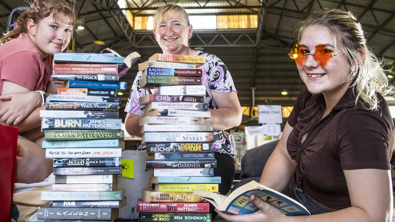 Surrounded in bargain book buys at Lifeline BookFest are (from left) Naomi, mum Michelle and Olivia Bennett. The Chronicle Lifeline BookFest at Toowoomba Showgrounds. Saturday, March 4, 2023. Picture: Nev Madsen.