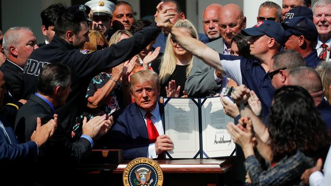 ‘You have gone far beyond your duty to us, and today we strive to fulfil our sacred duty to you’: Donald Trump signs the legislation for the 9/11 responders yesterday. Picture: Reuters
