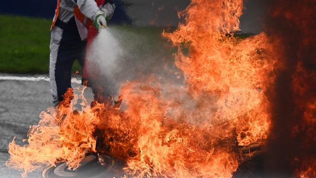 A track marshal tries to extinguish the fire following a crash involving Aprilia Italian rider Lorenzo Savadori and KTM Spanish rider Dani Pedrosa. Picture: AFP