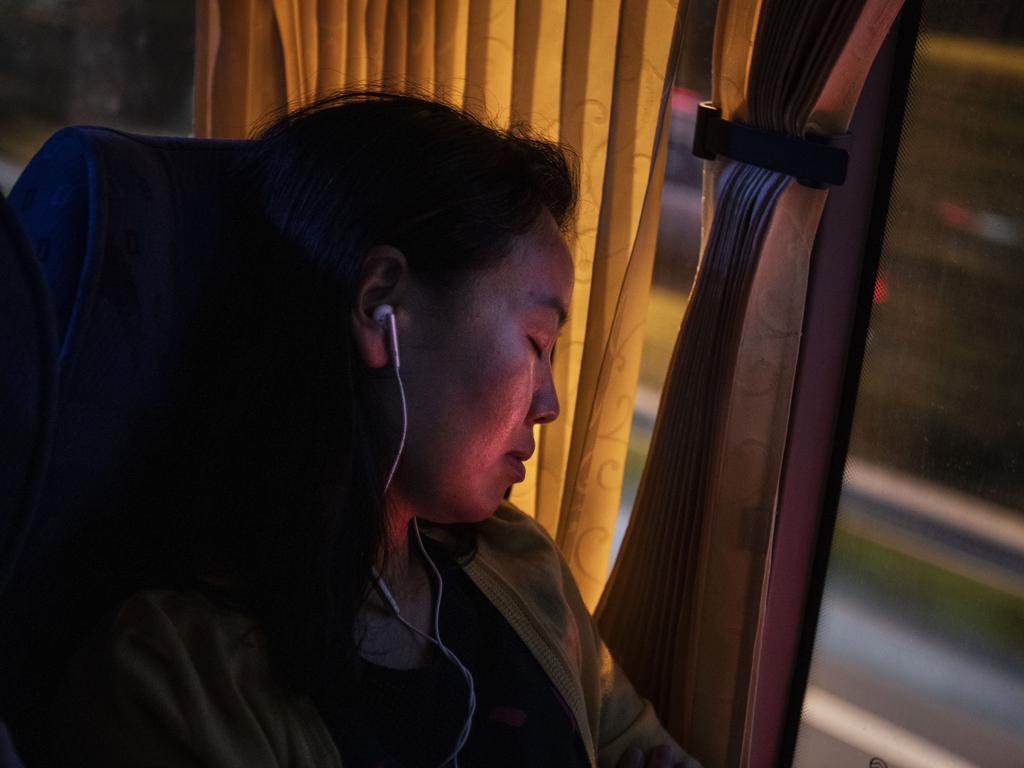 A Huawei employee sleeps as she rides the bus home at the end of the workday. Picture: Getty