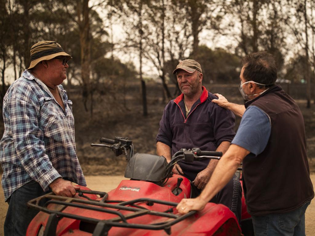 Steve Shipton (centre) is consoled by fellow farmers Bernie Smith (left) and Peter Mercieca in Coolagolite, NSW. Picture: AAP