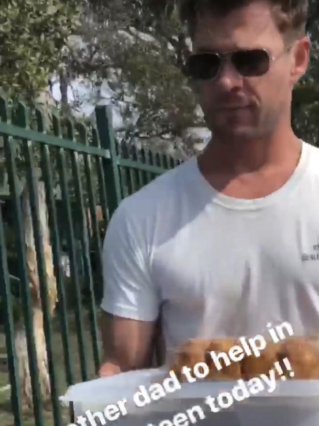 Chris Hemsworth entering Byron Bay Public School with containers of sushi. 