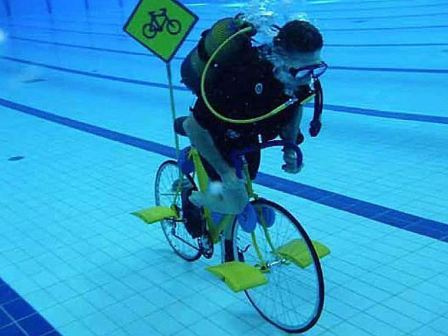 When he gets bored of land cycling, he takes it underwater. With street signs.