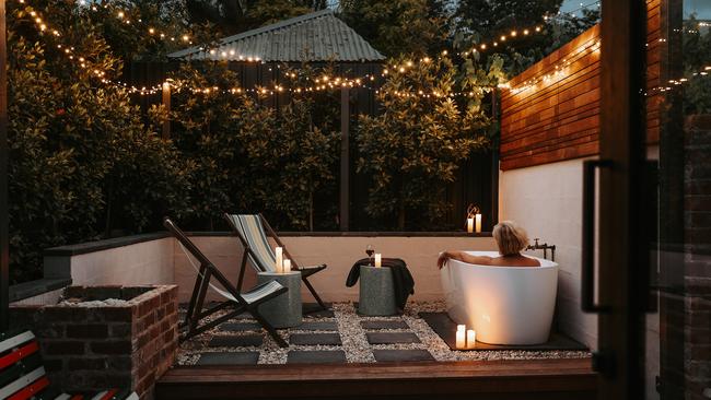 The outdoor bath at night under the fairy lights in the Braithwaite's private courtyard. Picture: Renee Thurston