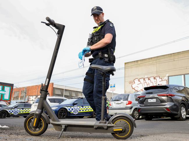 MELBOURNE, AUSTRALIA - NewsWire Photos OCTOBER 3, 2022 :  A policeman walks past a confiscated privately owned E-Scooter in Brunswick.Due to their speed they are illegal to be ridden outside of a personÃs private property and do not meet the standards of registration. Picture NCA NewsWire / Ian Currie