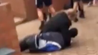 A still from shocking footage showing a 16-year-old student being held on the ground in a headlock by a staff member at Berwick Secondary College.