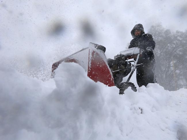 To the rescue ... Chris Boettcher clears snow along Route. 391 in Boston, New York, Tuesday after parts of New York measured the season's first big snowfall in feet, rather than inches. Pic: AP Photo/The Buffalo News, Harry Scull Jr.