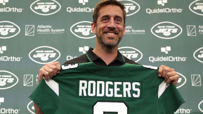 FLORHAM PARK, NEW JERSEY - APRIL 26: New York Jets quarterback Aaron Rodgers poses with a jersey during an introductory press conference at Atlantic Health Jets Training Center on April 26, 2023 in Florham Park, New Jersey. (Photo by Elsa/Getty Images)