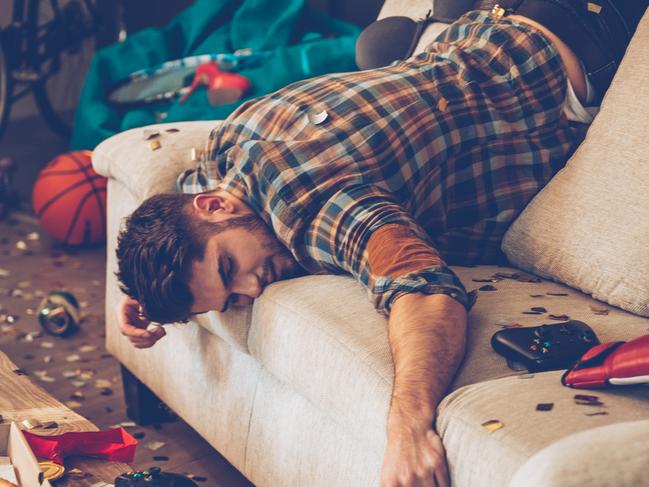 Young handsome man passed out on sofa in messy room after party Aribnb wild parties generic istock photo