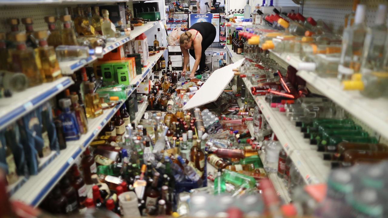 An employee cleans an aisle with toppled bottles scattered on the floor in a convenience store, following a 7.1 magnitude earthquake. Picture: AFP